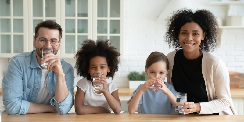family drinking water at table