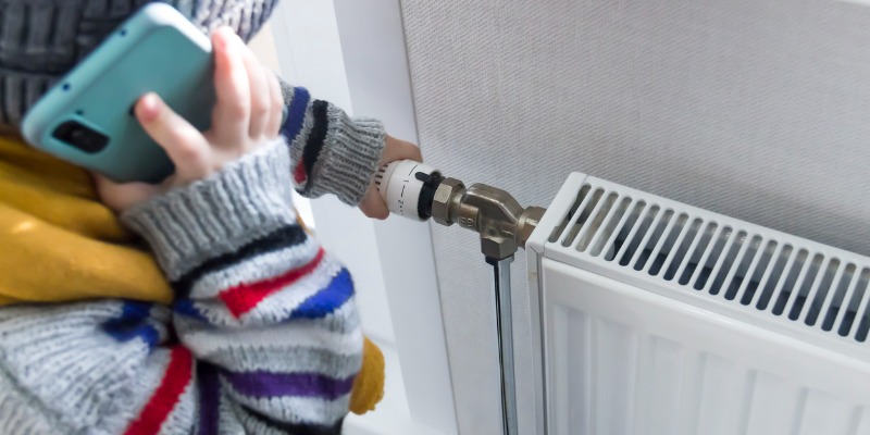 Person calling HVAC tech to fix hydronic heating system - Recognizing the Signs: When to Call a Hydronic Heating Repair Professional